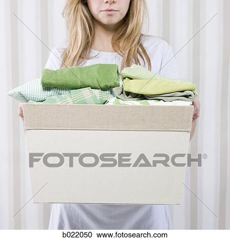 Stock Image - woman with a basket of folded clothes. Fotosearch