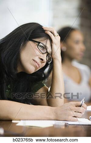 Stock Image - woman with a headache at work. Fotosearch