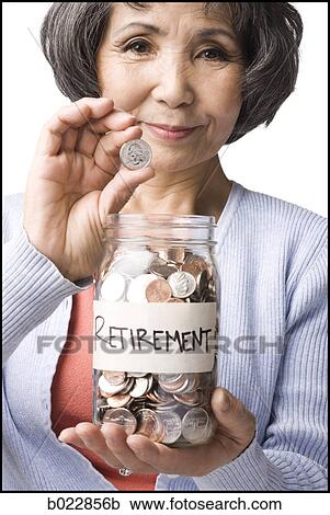 Stock Image - woman with a jar full of coins. Fotosearch