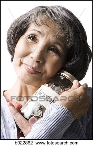 Stock Image - woman with a jar full of coins. Fotosearch