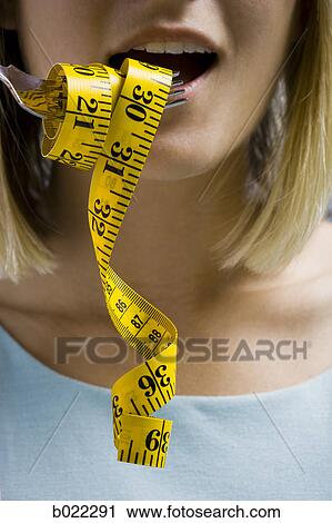 Stock Image - woman with a measuring tape on a fork. Fotosearch