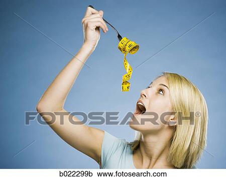 Stock Image - woman with a measuring tape on a fork. Fotosearch