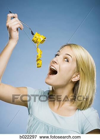 woman with a measuring tape on a fork View Large Photo Image Stock Photo - woman with a measuring tape on a fork. Fotosearch