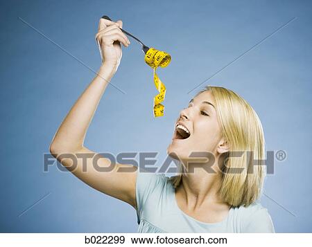 Stock Photo - woman with a measuring tape on a fork. Fotosearch
