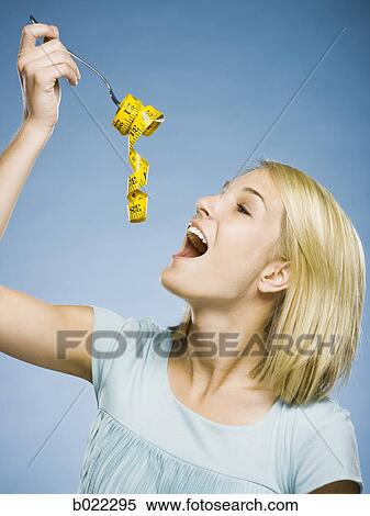 woman with a measuring tape on a fork View Large Photo Image Stock Photography - woman with a measuring tape on a fork. Fotosearch