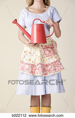 Stock Image - woman with a watering can. Fotosearch
