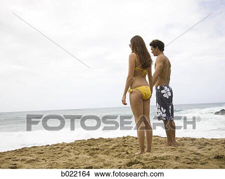 young couple at the beach holding hands View Large Photo Image Picture - young couple at the beach holding hands. Fotosearch