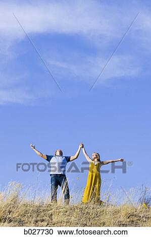 young couple holding hands on a ridge View Large Photo Image Stock Image - young couple holding hands on a ridge. Fotosearch