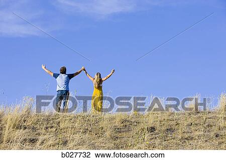 young couple holding hands on a ridge View Large Photo Image Stock Image - young couple holding hands on a ridge. Fotosearch