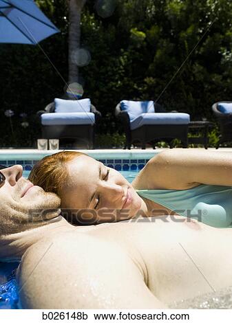 Stock Image - young couple in a swimming pool. Fotosearch