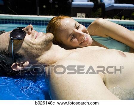 Stock Image - young couple in a swimming pool. Fotosearch