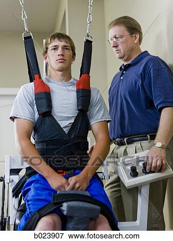 Stock Photo - young man in a suspension harness. Fotosearch