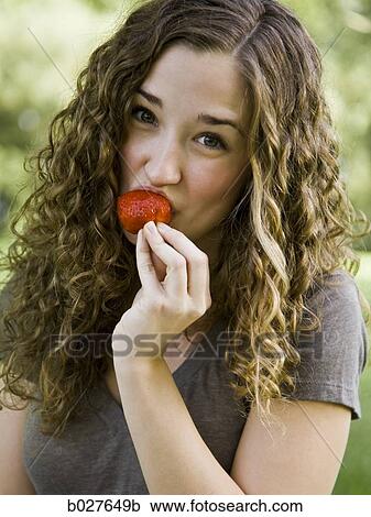 young woman eating a berry View Large Photo Image Stock Image - young woman eating a berry. Fotosearch