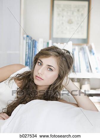 Picture - young woman lying on her bed. Fotosearch