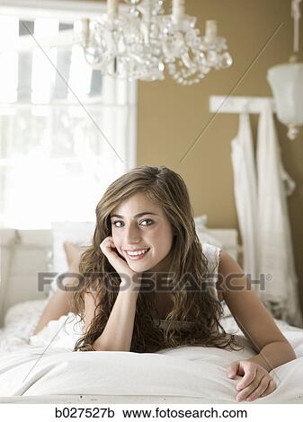 young woman lying on her bed View Large Photo Image Stock Image - young woman lying on her bed. Fotosearch