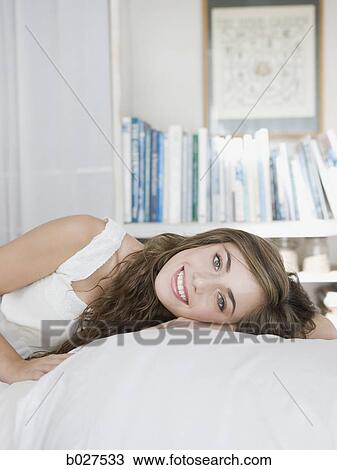 young woman lying on her bed View Large Photo Image Stock Image - young woman lying on her bed. Fotosearch