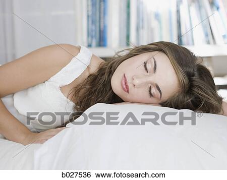Stock Photograph - young woman lying on her bed. Fotosearch