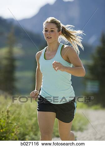young woman running on a mountain trail View Large Photo Image Stock Photograph - young woman running on a mountain trail. Fotosearch