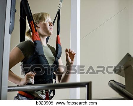 young woman running on a treadmill in a harness View Large Photo Image Stock Photography - young woman running on a treadmill in a harness. Fotosearch