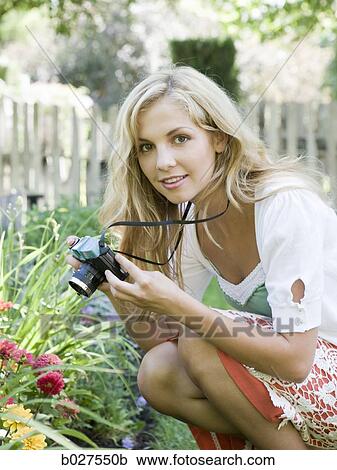 young woman taking pictures in the garden View Large Photo Image Stock Image - young woman taking pictures in the garden. Fotosearch