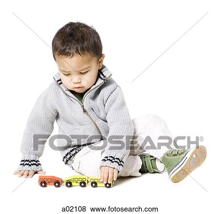 Baby boy (18-23 months) playing with toy cars, against white background View Large Photo Image Stock Photo - Baby boy (18-23 months) playing with toy cars, against white background. Fotosearch