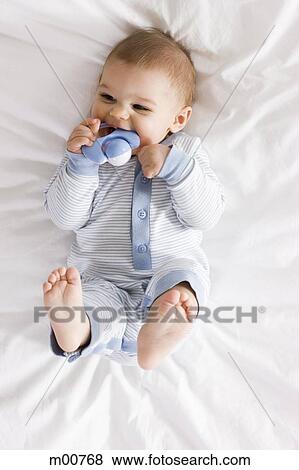 baby boy lying on a bed View Large Photo Image Stock Photo - baby boy lying on a bed. Fotosearch