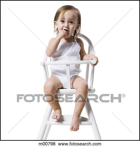 Stock Photo - baby girl in a high chair. Fotosearch
