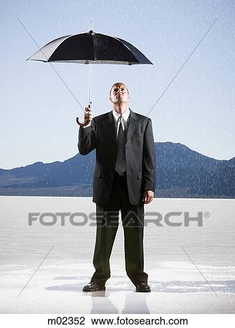 businessperson holding an umbrella in the desert View Large Photo Image Stock Image - businessperson holding an umbrella in the desert. Fotosearch