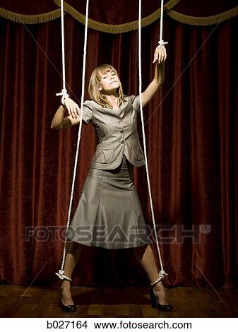 businesswoman being pulled by strings like a puppet View Large Photo Image Picture - businesswoman being pulled by strings like a puppet. Fotosearch