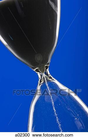Close-up of hourglass on blue background View Large Photo Image Stock Image - Close-up of hourglass on blue background. Fotosearch