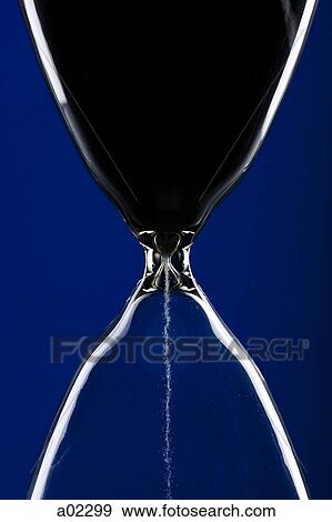 Stock Photo - Close-up of hourglass on blue background. Fotosearch
