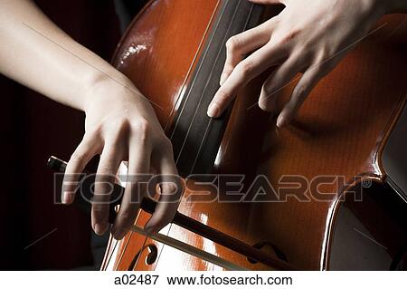 Close-up of young woman playing cello View Large Photo Image Stock Photo - Close-up of young woman playing cello. Fotosearch