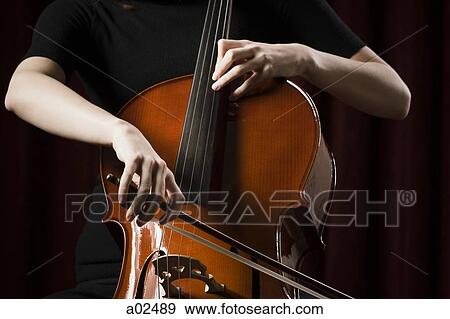 Stock Photo - Close-up of young woman playing cello. Fotosearch