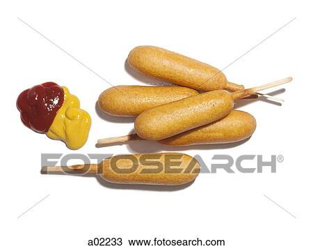 Stock Image - Corndogs with ketchup and mustard, view from above, studio shot. Fotosearch