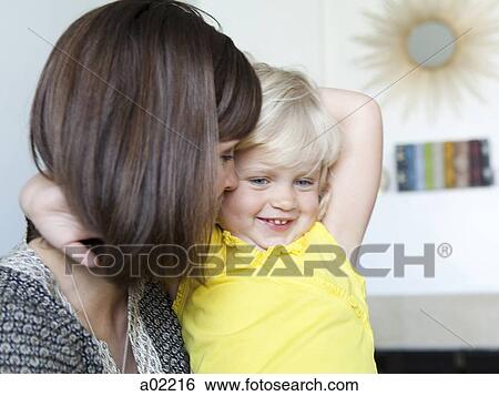 Stock Photograph - Daughter (2-3) embracing mother, close-up. Fotosearch