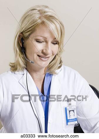 Female nurse using headset, studio shot View Large Photo Image Stock Image - Female nurse using headset, studio shot. Fotosearch