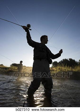 Stock Image - fly fisherman fishing in a mountain river. Fotosearch