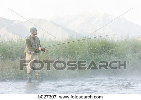 Stock Photo - fly fisherman fishing in a mountain river. Fotosearch