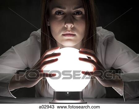 Stock Image - Fortune teller holding crystal ball, portrait. Fotosearch