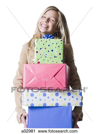 Girl (10--11) holding a stack of presents, portrait View Large Photo Image Stock Image - Girl (10--11) holding a stack of presents, portrait. Fotosearch