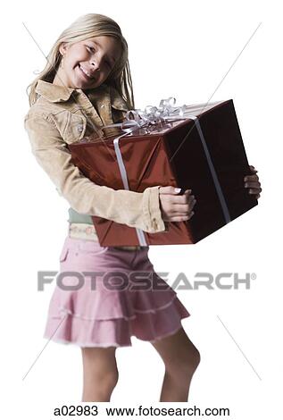 Stock Image - Girl (10--11) standing with gift, portrait. Fotosearch