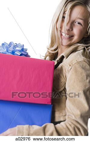 Girl (10--11) standing with gifts, portrait View Large Photo Image Stock Photograph - Girl (10--11) standing with gifts, portrait. Fotosearch