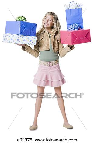 Stock Photography - Girl (10--11) standing with gifts, portrait. Fotosearch