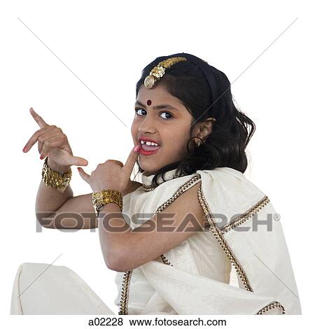 Girl (8-9) wearing traditional sari performing figures from indian traditional dance, studio shot View Large Photo Image Stock Photo - Girl (8-9) wearing traditional sari performing figures from indian traditional dance, studio shot. Fotosearch