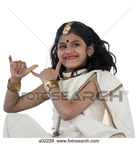 Girl (8-9) wearing traditional sari performing figures from indian traditional dance, studio shot View Large Photo Image Stock Photo - Girl (8-9) wearing traditional sari performing figures from indian traditional dance, studio shot. Fotosearch