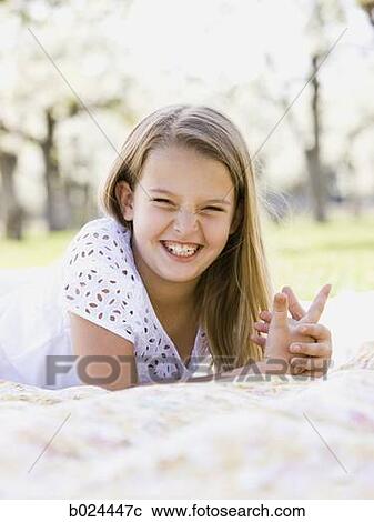 Stock Image - girl lying on a blanket. Fotosearch
