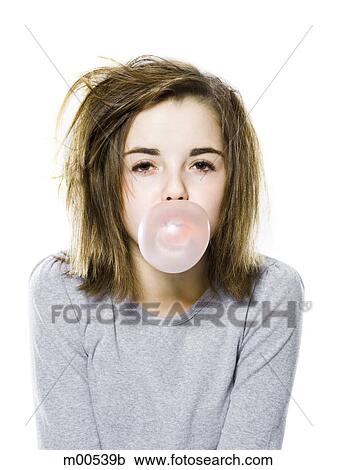 Stock Image - girl with a messy appearance popping a bubble gum bubble. Fotosearch