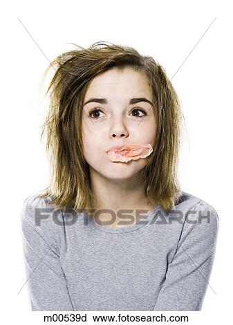 Stock Image - girl with a messy appearance popping a bubble gum bubble. Fotosearch