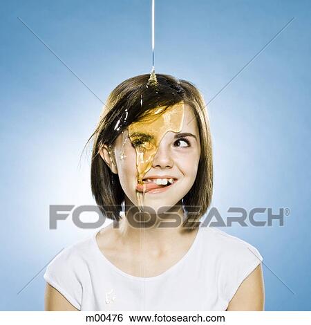 Stock Photograph - girl with honey pouring on her head. Fotosearch