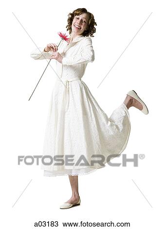 Happy young woman dancing with gerbera flower, portrait, studio shot View Large Photo Image Stock Image - Happy young woman dancing with gerbera flower, portrait, studio shot. Fotosearch